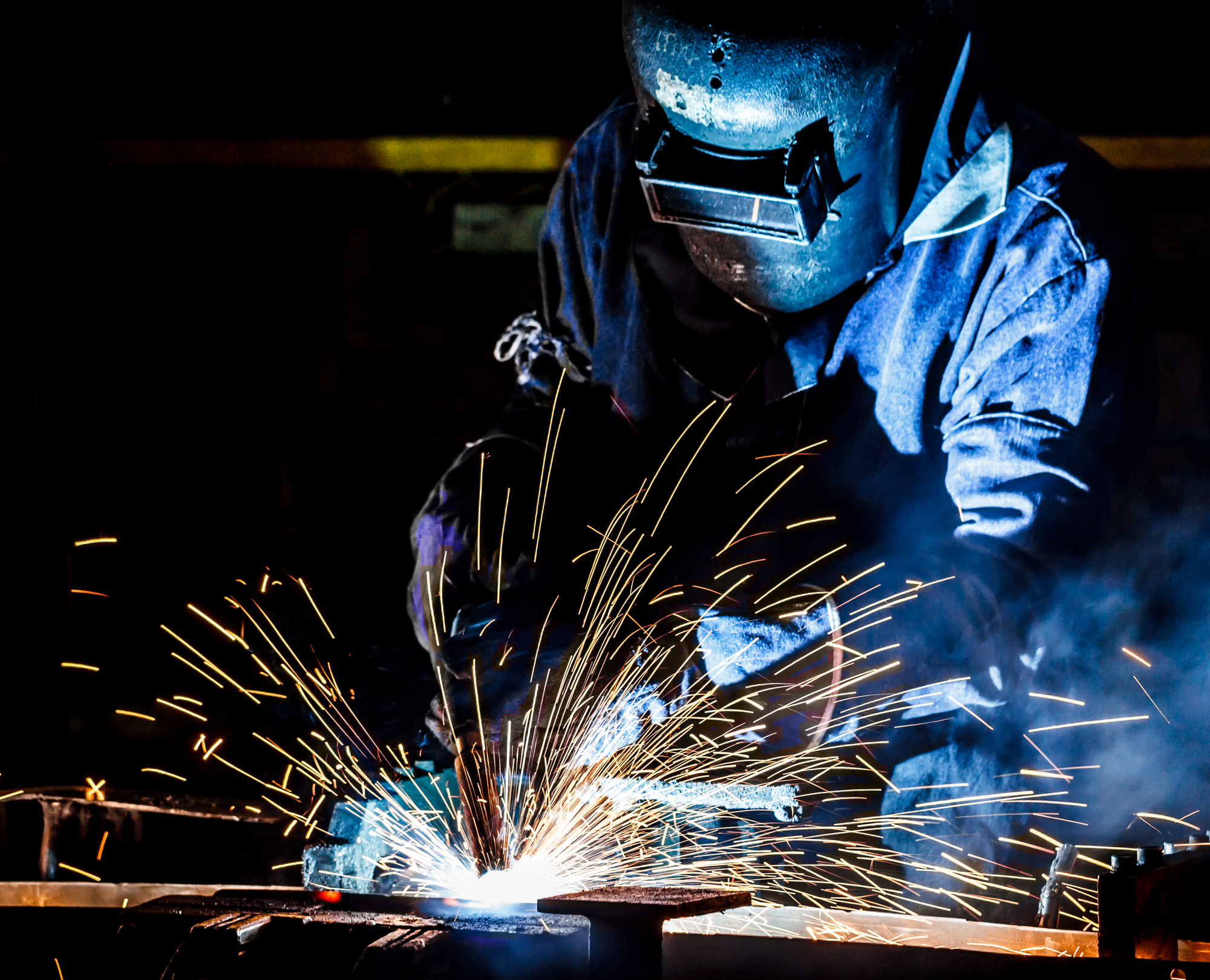 worker with protective mask welding metal